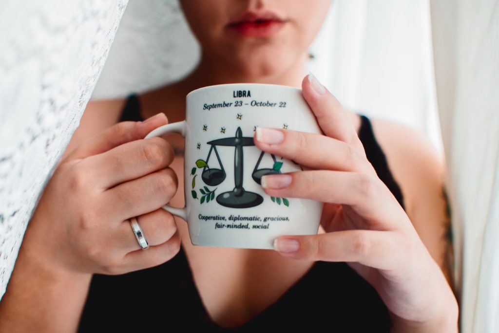 girl drinking from coffee mug with libra sign